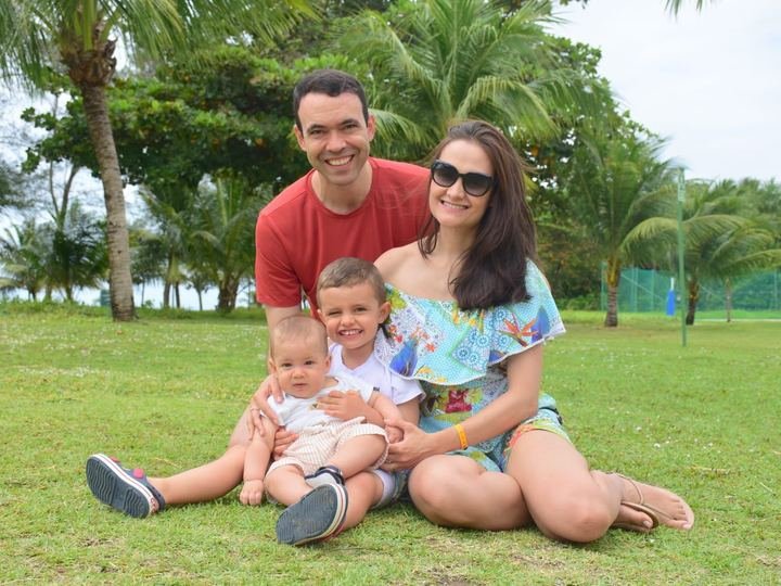 Marina Zerlotini com o marido e os filhos sentados na grama